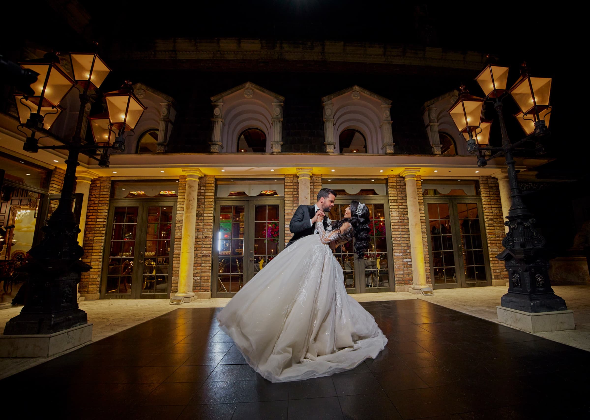 First dance on the courtyard floor at night beneath lit gas lanterns — The Cruz Building wedding venue, Miami, Florida