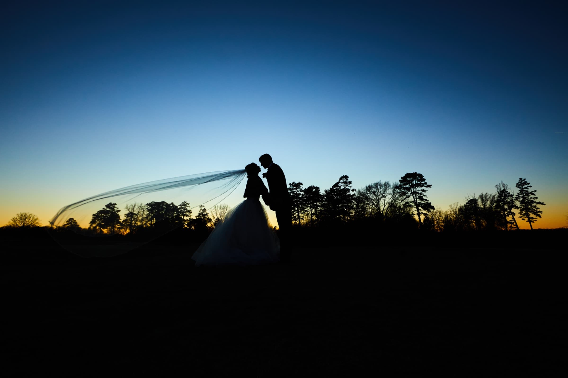 Blue-hour silhouette with the veil sweeping across an orange horizon — Forsyth Country Club