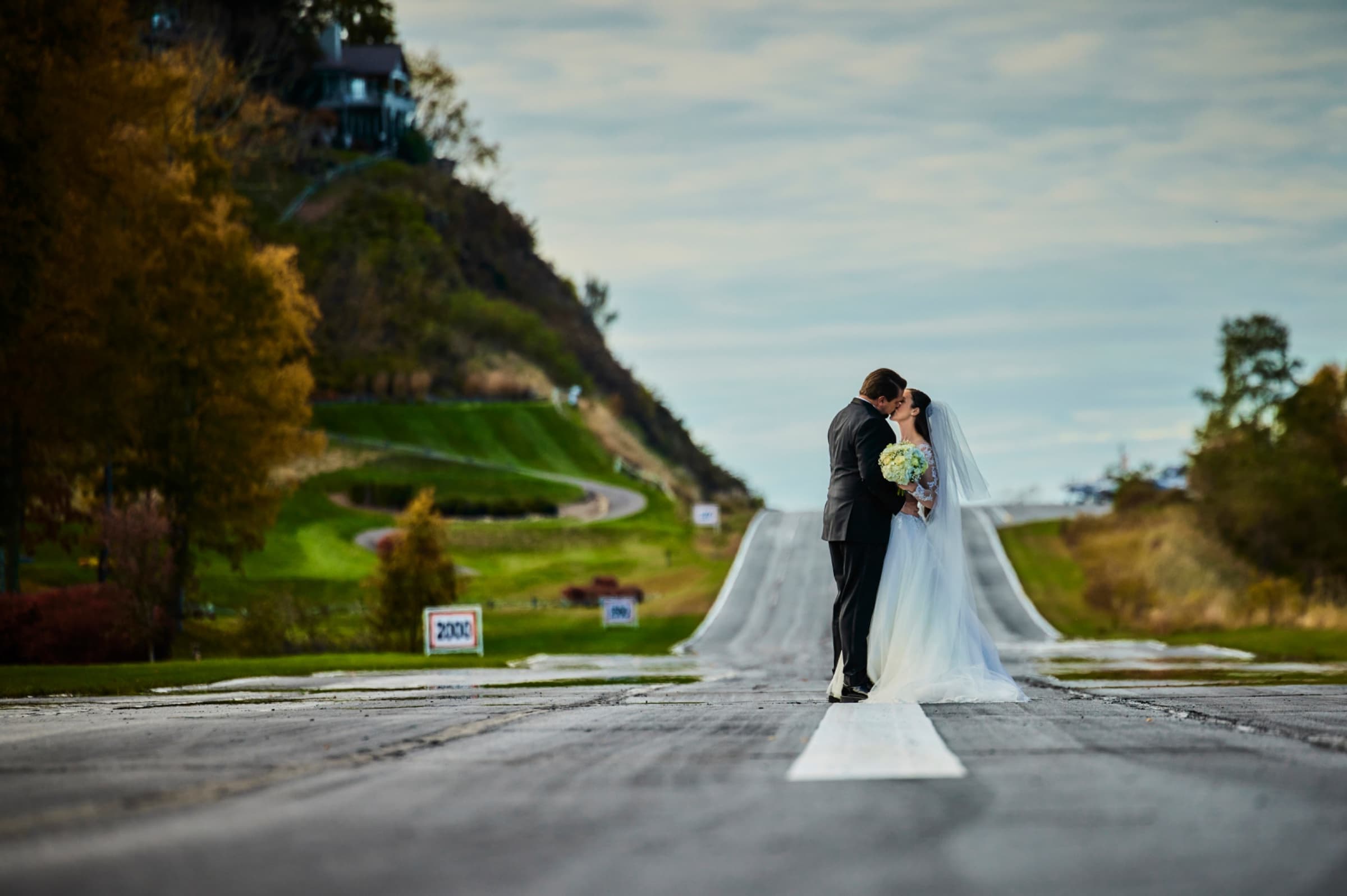 Couple on the mountain road with the ridgeline falling away behind — Mountain Air Country Club
