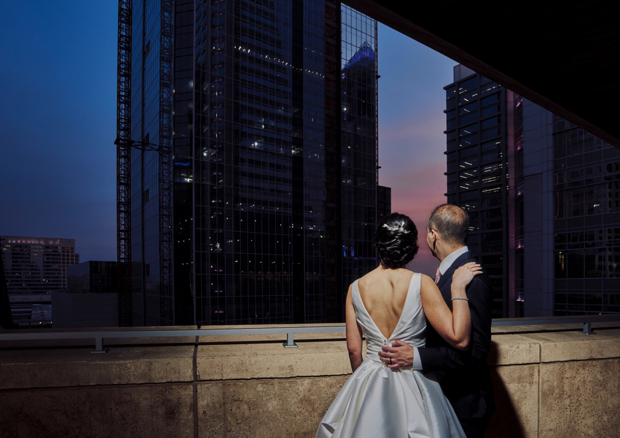 Couple on the terrace at blue hour with the Charlotte skyline lit behind — The Mint Museum
