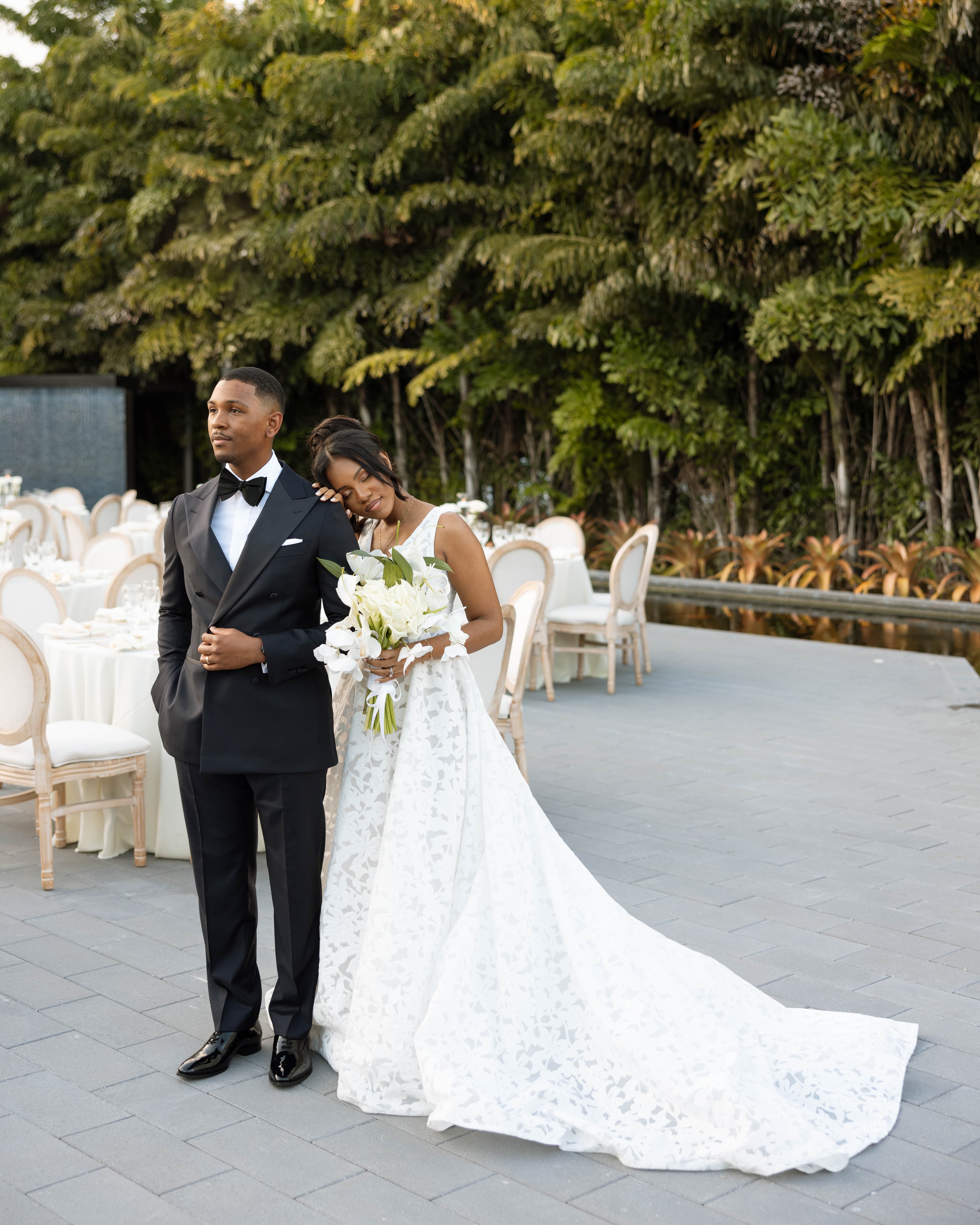 Bride and groom in a quiet moment beside the set reception tables at The Glass Venue