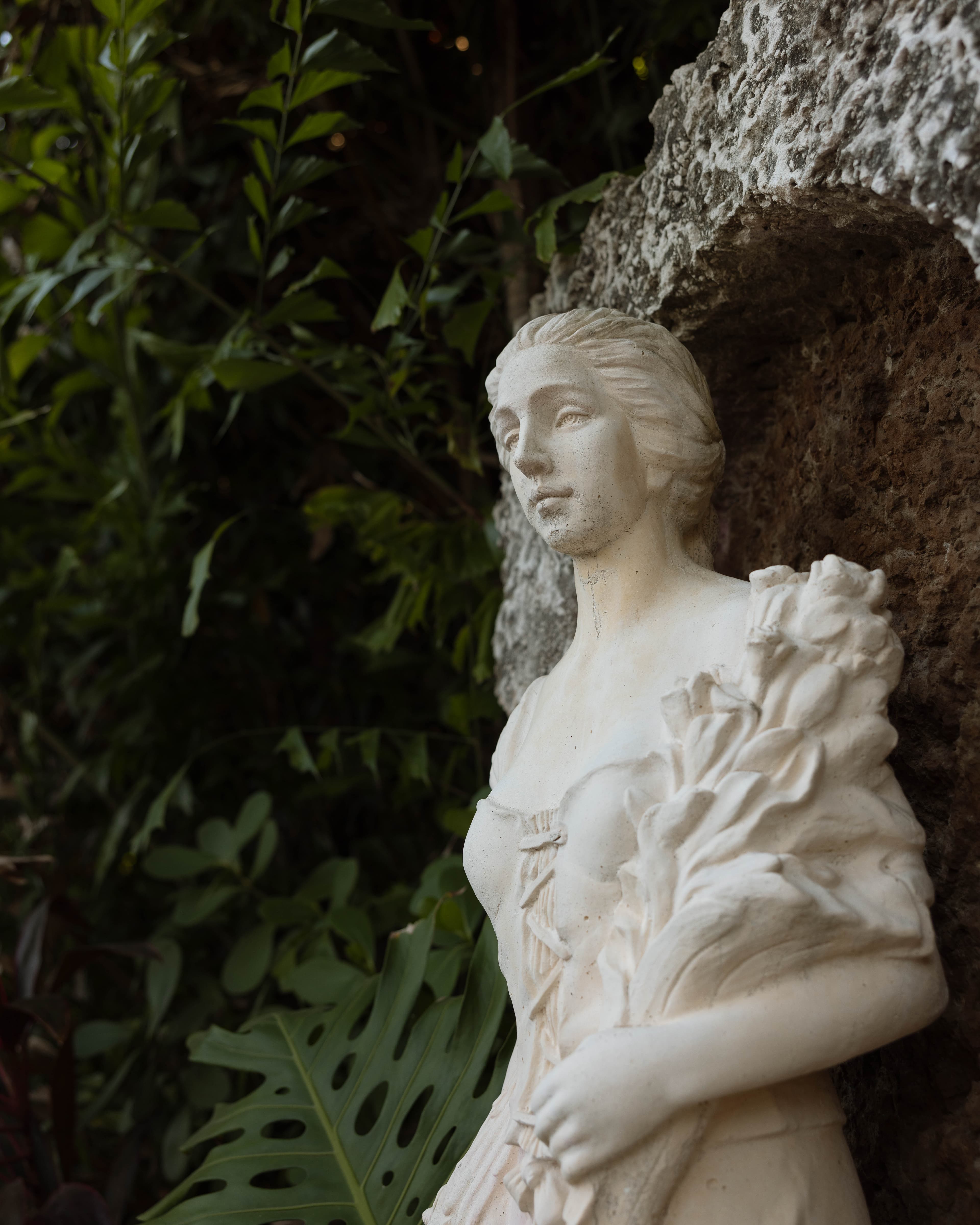 Statue detail among tropical foliage — Villa Toscana Miami wedding venue, Homestead, Florida