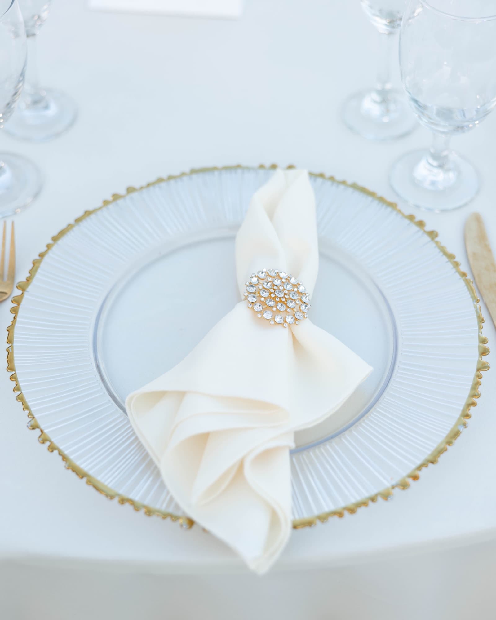 A napkin ring holding a folded napkin on a beaded charger — The Glass Venue wedding venue, Miami, Florida