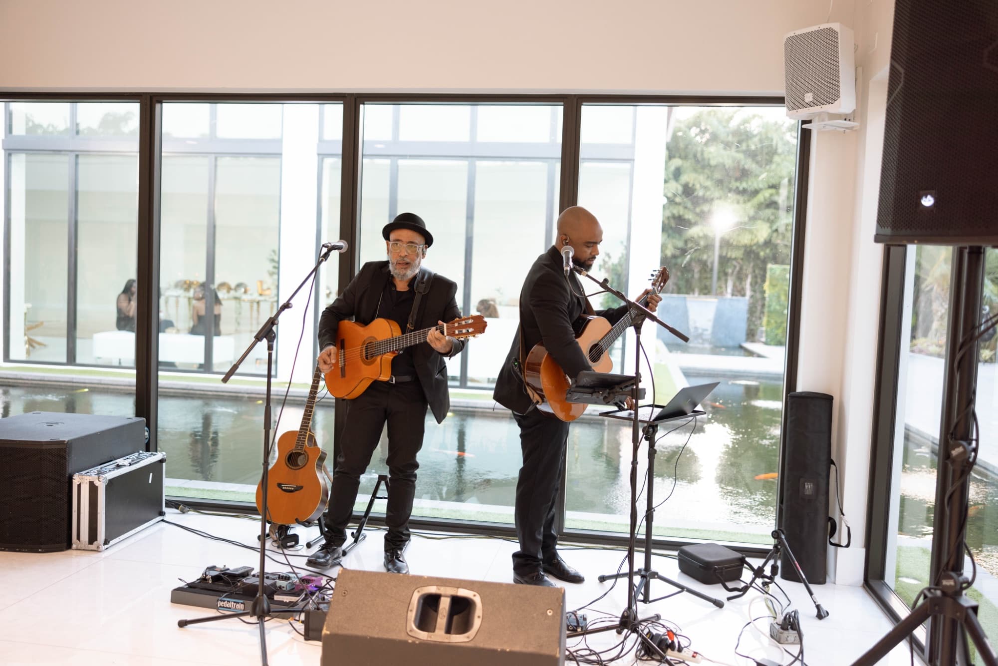 The band playing inside the glass-walled room — The Glass Venue wedding venue, Miami, Florida